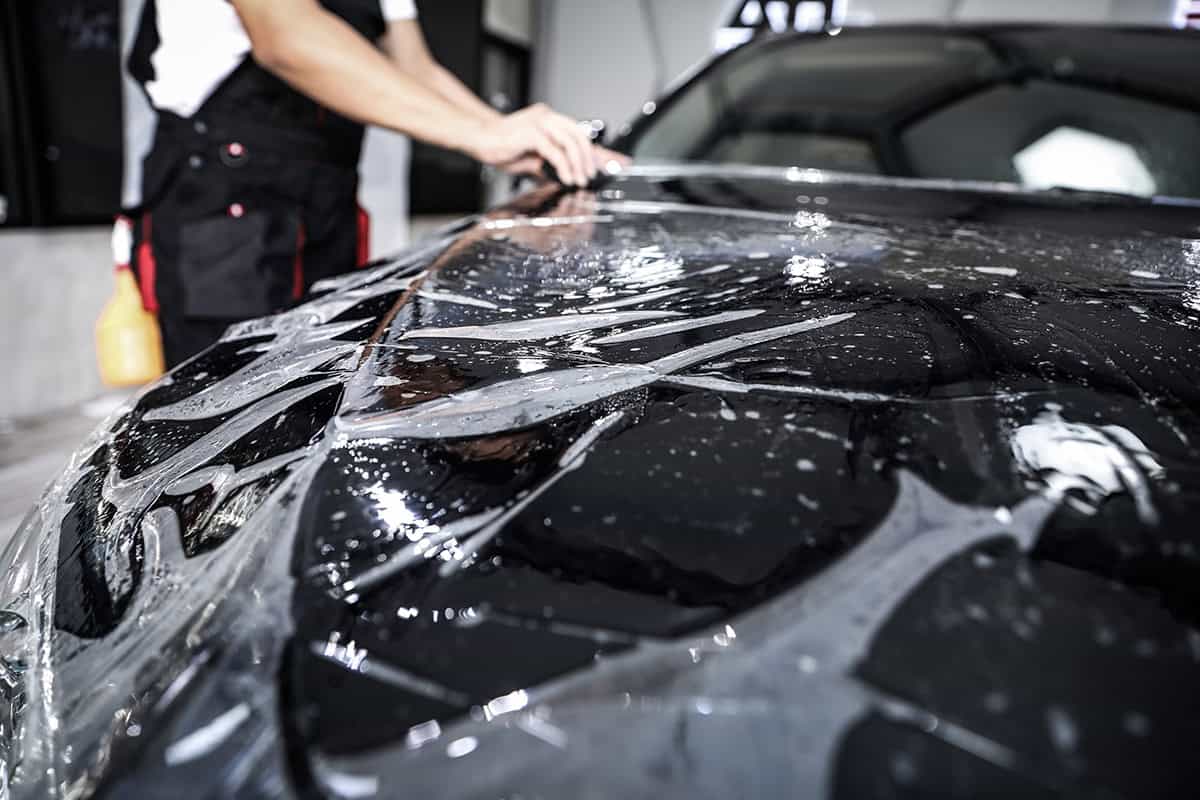 Close up of paint protection film installation on front bumper o